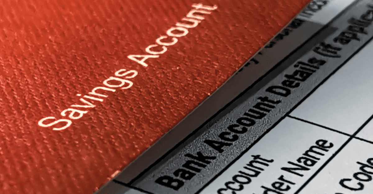 a savings account passbook resting on a bank account details application form